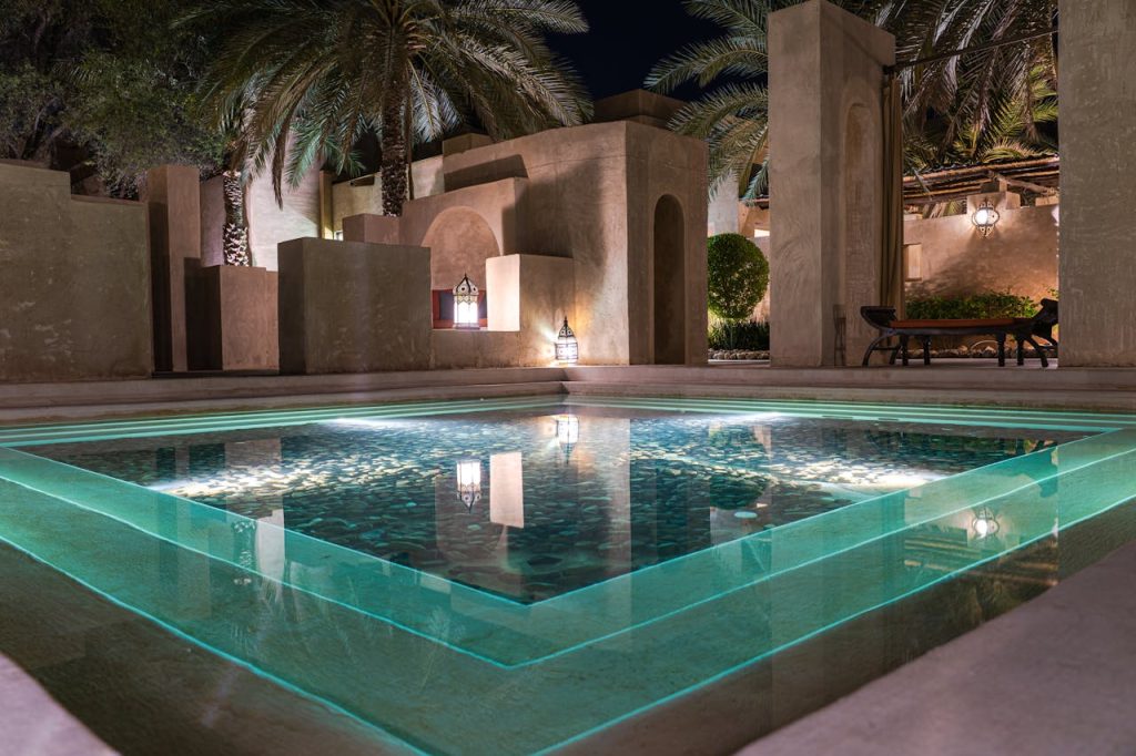 Stunning nighttime view of a luxury Arabian-style pool with ambient lighting in Dubai.