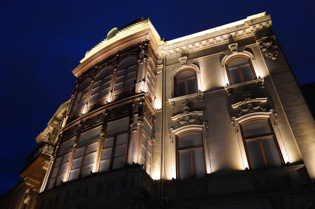 Dramatic view of a historic buildings facade beautifully lit against a deep blue night sky.