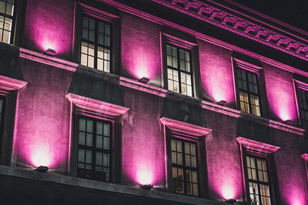 A building exterior in Iceland, highlighted by dramatic pink lighting during the night.